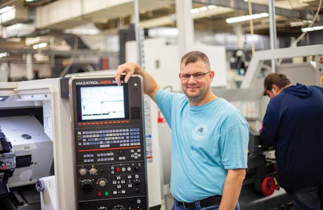 Individual standing next to machine with keyboard and display panel